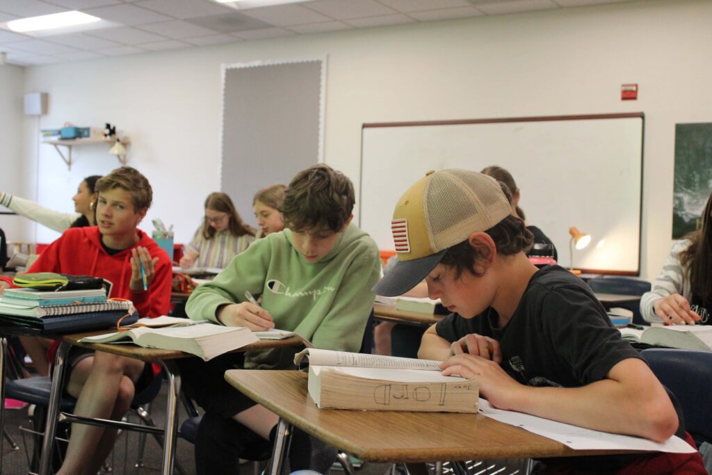 Middle school boys read their Bibles in the classroom.