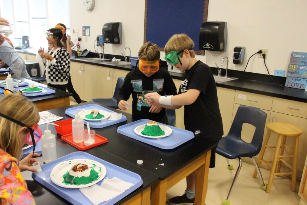 Two boys work on volcano experiments in science lab at West Hills Christian School.